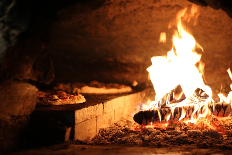 Wood-fired brick oven with flames and pizza cooking